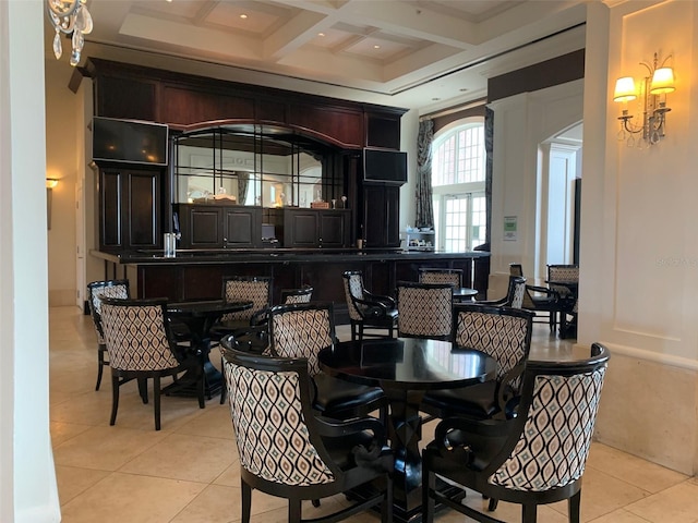 dining area with light tile patterned floors, beamed ceiling, and coffered ceiling