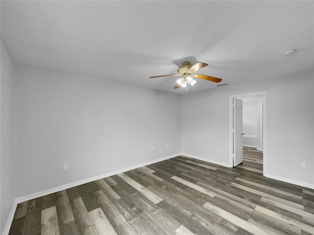 empty room featuring dark wood-type flooring and ceiling fan