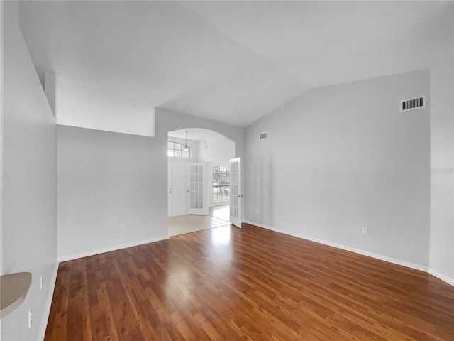 unfurnished living room with hardwood / wood-style flooring and high vaulted ceiling