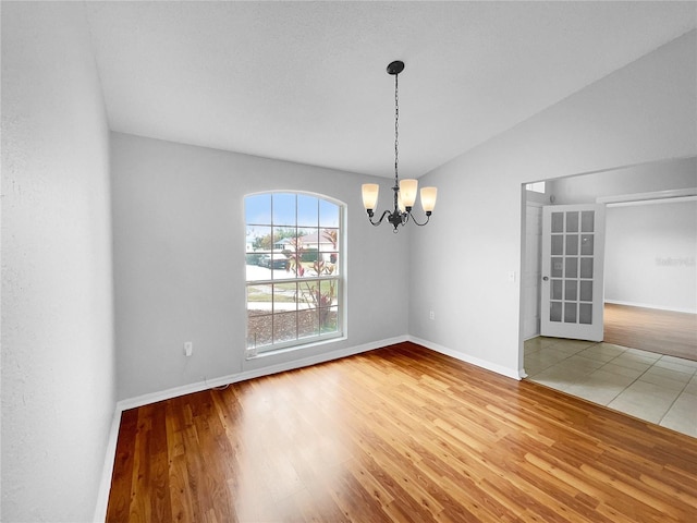 unfurnished dining area with an inviting chandelier, hardwood / wood-style floors, and vaulted ceiling