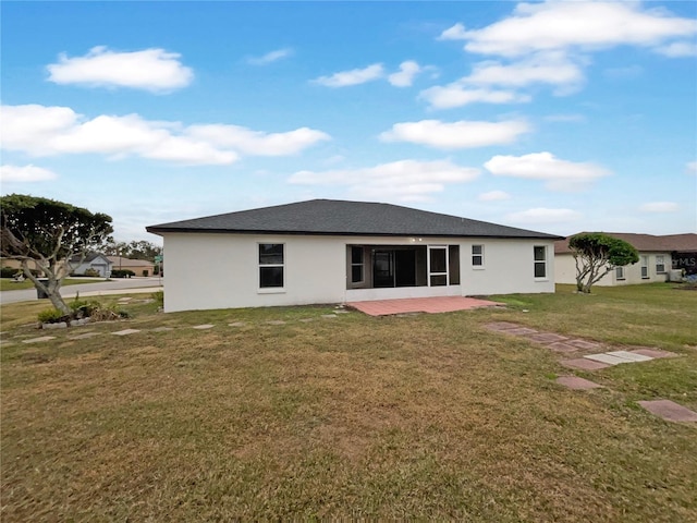 rear view of house with a lawn and a patio area