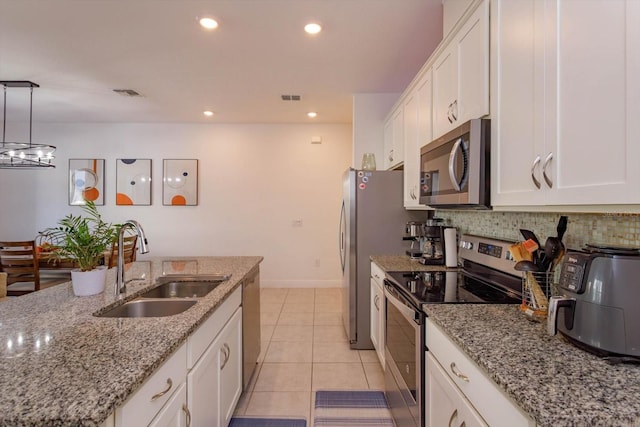 kitchen featuring sink, stainless steel appliances, white cabinetry, and hanging light fixtures