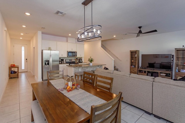 dining area featuring ceiling fan with notable chandelier and light tile patterned floors