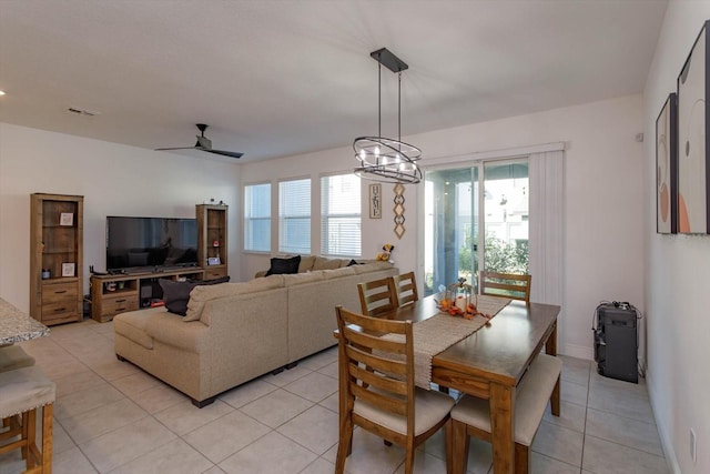 tiled dining area featuring a healthy amount of sunlight and ceiling fan with notable chandelier