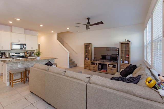 tiled living room featuring ceiling fan and a healthy amount of sunlight