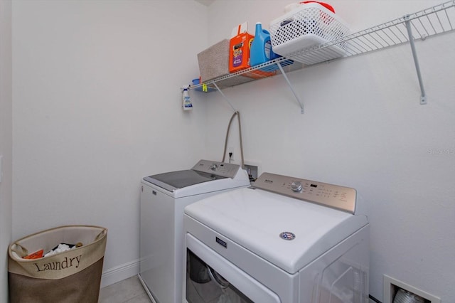 washroom featuring washing machine and clothes dryer and light tile patterned floors