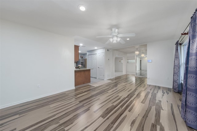 unfurnished living room featuring light hardwood / wood-style floors and ceiling fan