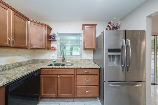 kitchen with light stone countertops, black dishwasher, decorative backsplash, sink, and stainless steel fridge with ice dispenser