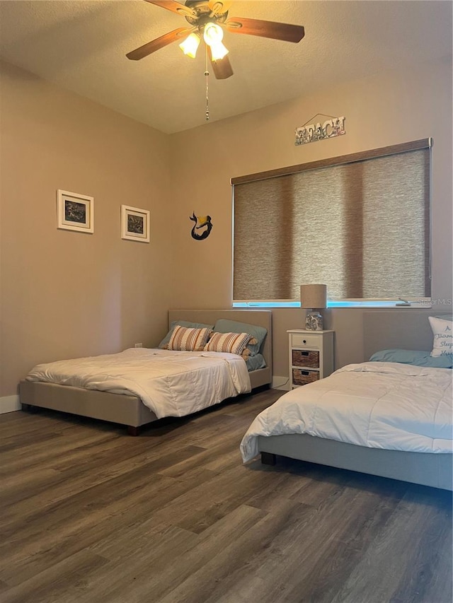 bedroom with ceiling fan and dark wood-type flooring