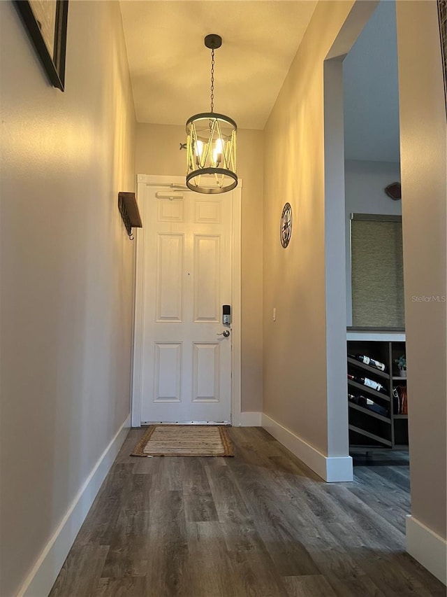 foyer entrance featuring dark hardwood / wood-style floors and a notable chandelier