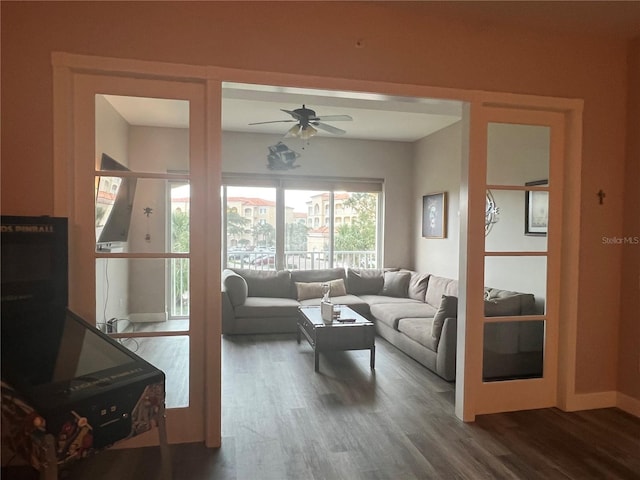 living room featuring ceiling fan and dark wood-type flooring