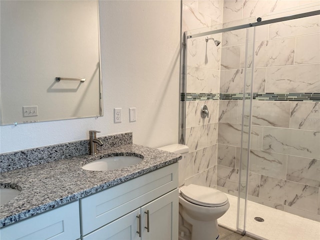 bathroom with walk in shower, vanity, and toilet