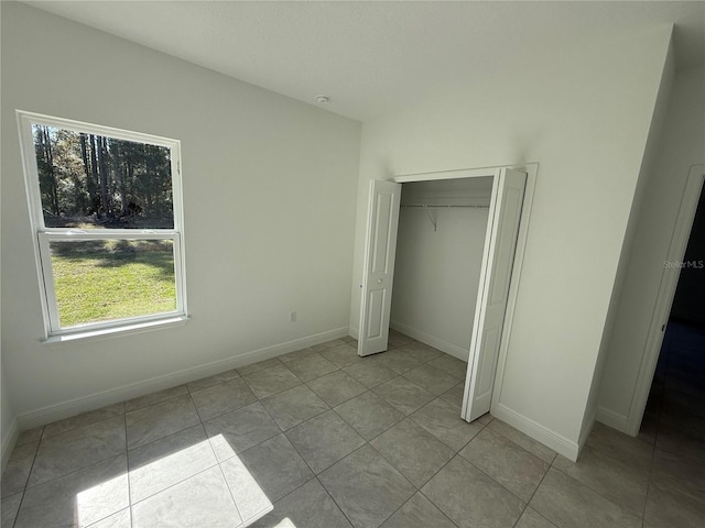 unfurnished bedroom with a closet and light tile patterned floors