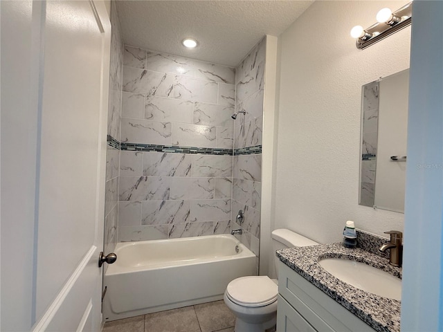 full bathroom featuring a textured ceiling, tiled shower / bath, tile patterned flooring, toilet, and vanity