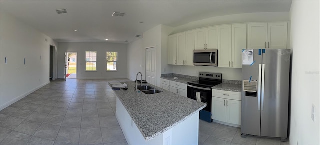 kitchen featuring light stone counters, stainless steel appliances, an island with sink, white cabinets, and sink