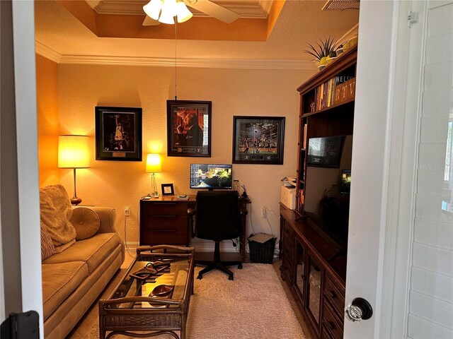 office featuring ceiling fan, light colored carpet, ornamental molding, and a raised ceiling