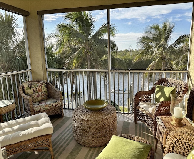 sunroom featuring a water view