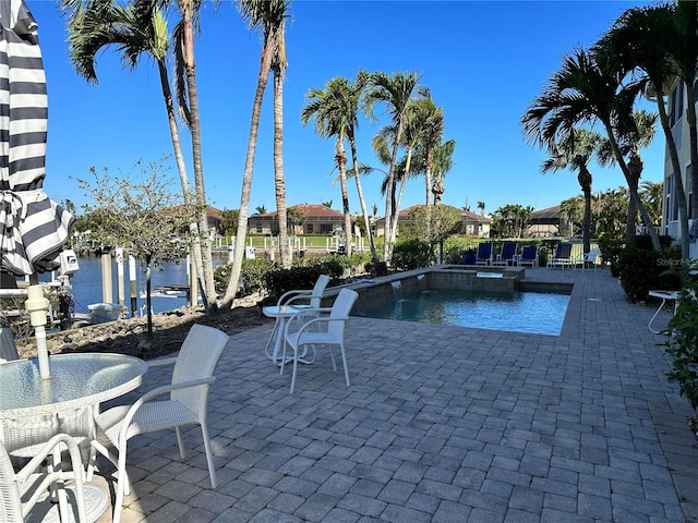 view of swimming pool with a patio area and a water view