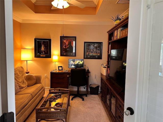 home office with a ceiling fan, a tray ceiling, crown molding, and carpet flooring