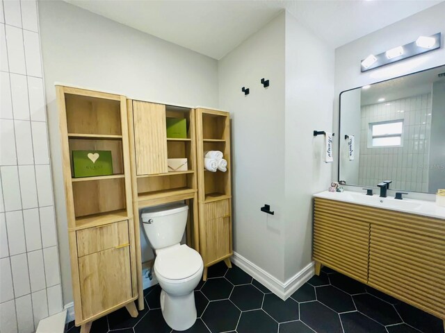 bathroom featuring tile patterned flooring, vanity, and toilet