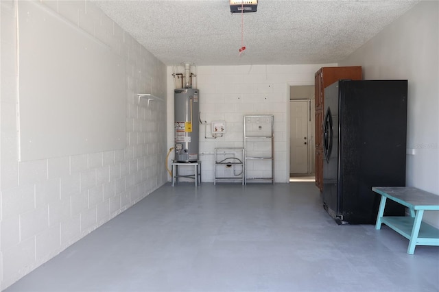 garage with a garage door opener, black refrigerator, and water heater