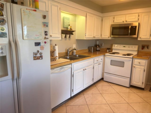 kitchen with white cabinetry, white appliances, sink, and light tile patterned floors