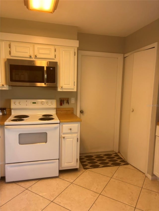 kitchen featuring white cabinetry, white range with electric cooktop, and light tile patterned flooring