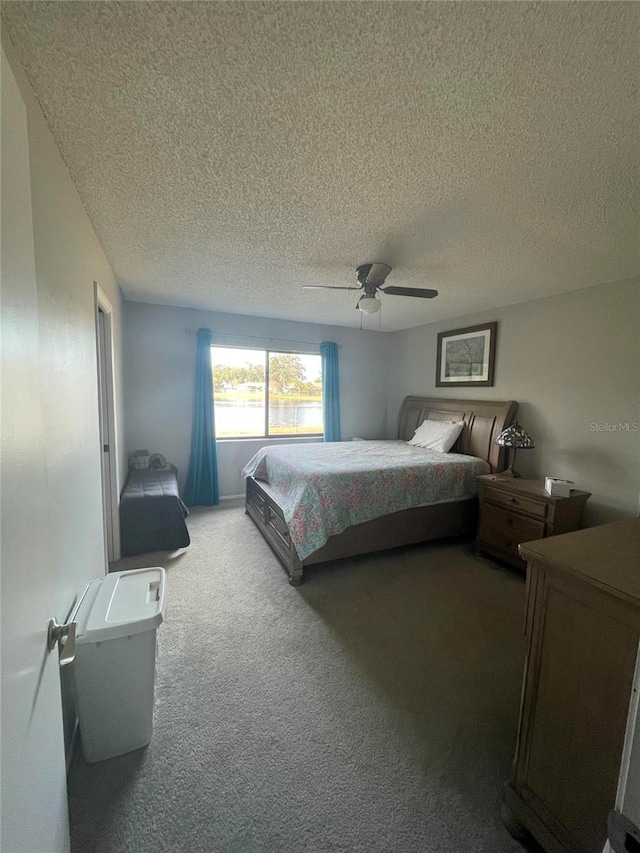 carpeted bedroom featuring a textured ceiling and ceiling fan