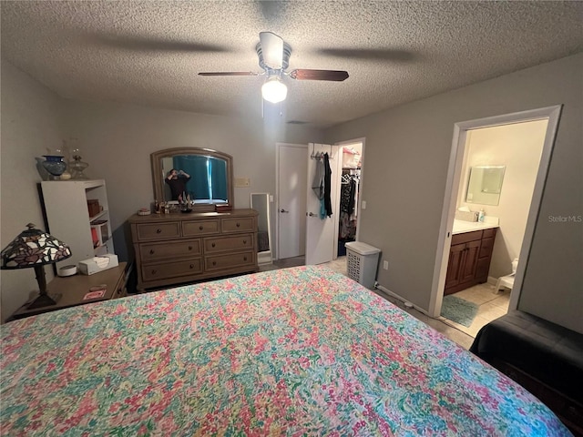 bedroom with a spacious closet, a textured ceiling, a closet, and ceiling fan