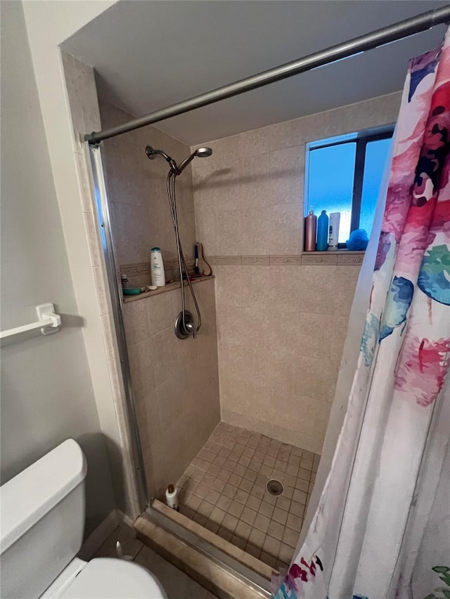 bathroom with curtained shower and toilet