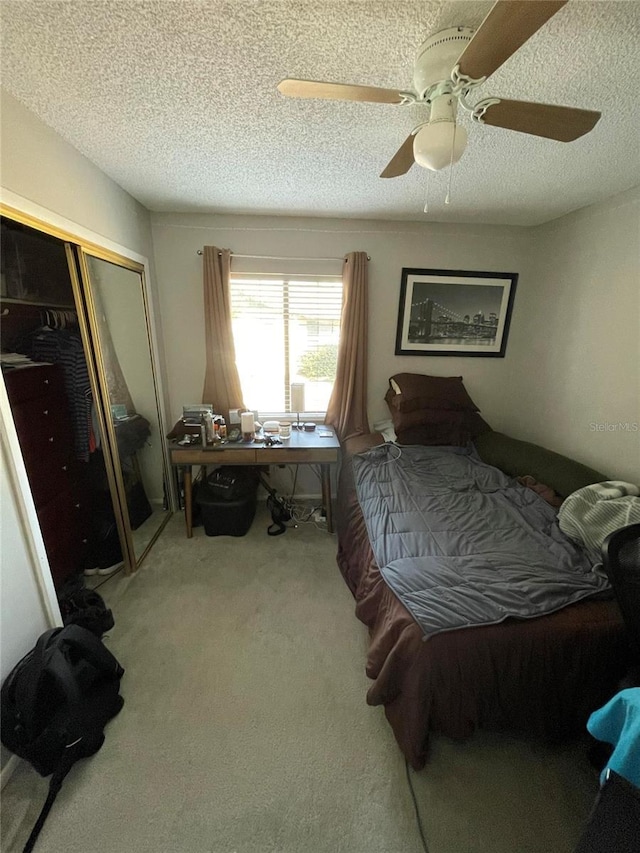 bedroom featuring carpet, a textured ceiling, ceiling fan, and a closet