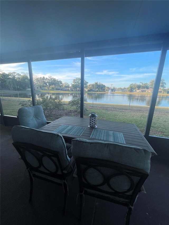 sunroom featuring a water view