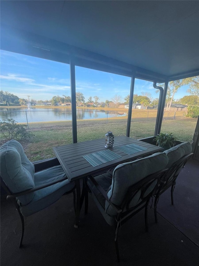 sunroom featuring a water view