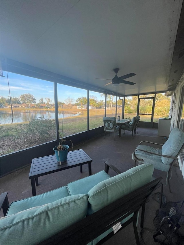 sunroom with a water view and ceiling fan