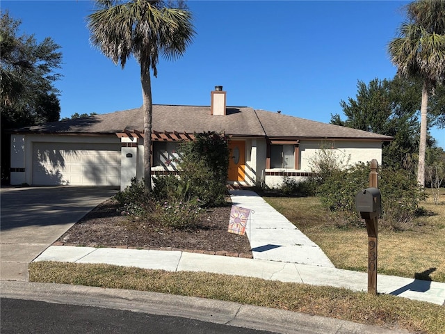 single story home with a garage, concrete driveway, a chimney, and stucco siding