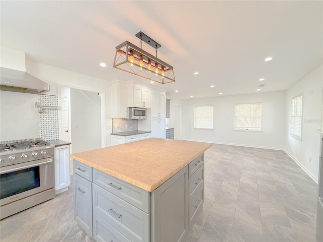 kitchen with white cabinetry, stainless steel appliances, tasteful backsplash, decorative light fixtures, and a kitchen island