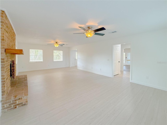 unfurnished living room with ceiling fan, a fireplace, and light hardwood / wood-style floors