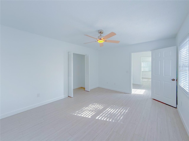 empty room with ceiling fan and light wood-type flooring