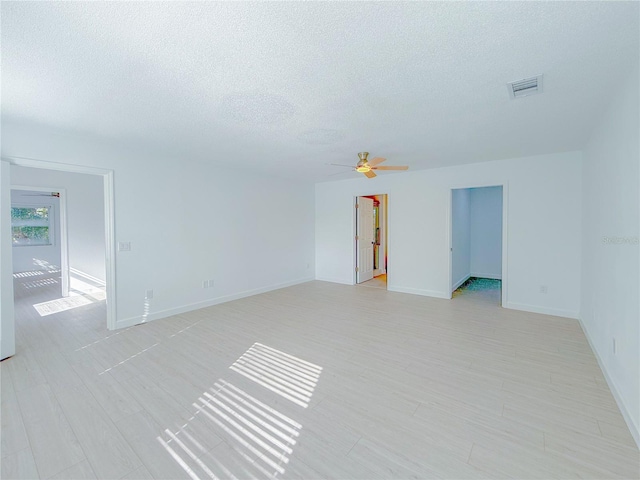 unfurnished room with ceiling fan and a textured ceiling