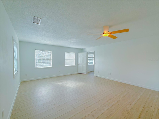 unfurnished room with ceiling fan, light hardwood / wood-style floors, and a textured ceiling