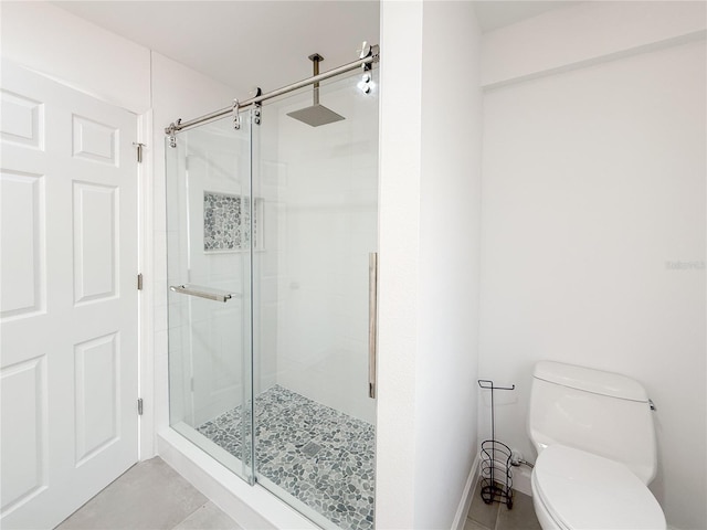 bathroom featuring an enclosed shower, toilet, and tile patterned floors