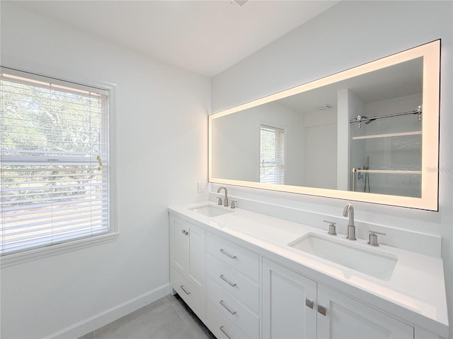 bathroom with tile patterned floors, vanity, and walk in shower