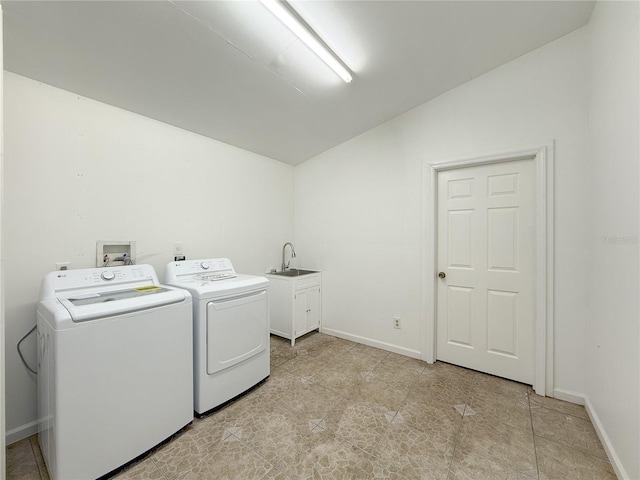 laundry area with cabinets, washing machine and dryer, and sink