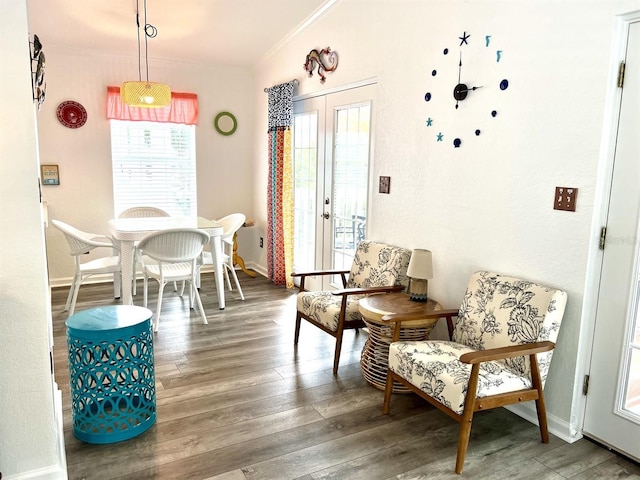 sitting room featuring wood-type flooring, ornamental molding, and french doors