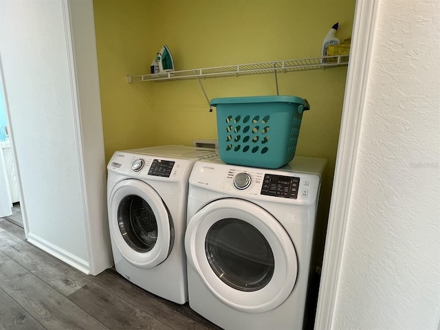 laundry area with hardwood / wood-style flooring and washing machine and dryer