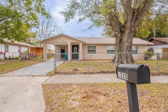 single story home featuring a fenced front yard, an attached carport, concrete driveway, and stucco siding