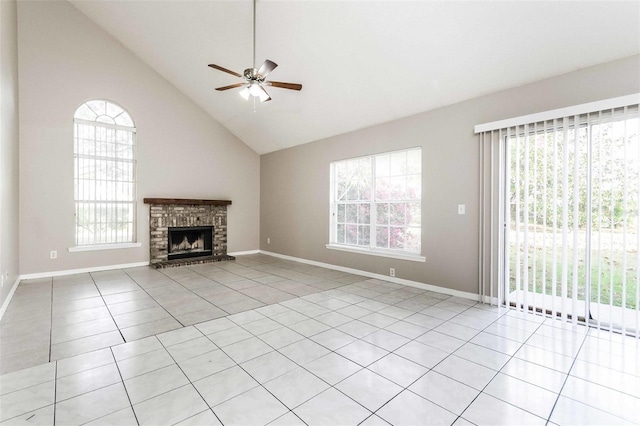 unfurnished living room featuring a fireplace, light tile patterned floors, ceiling fan, and a healthy amount of sunlight