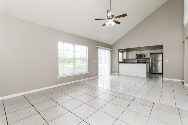 unfurnished living room with ceiling fan, light tile patterned floors, and high vaulted ceiling