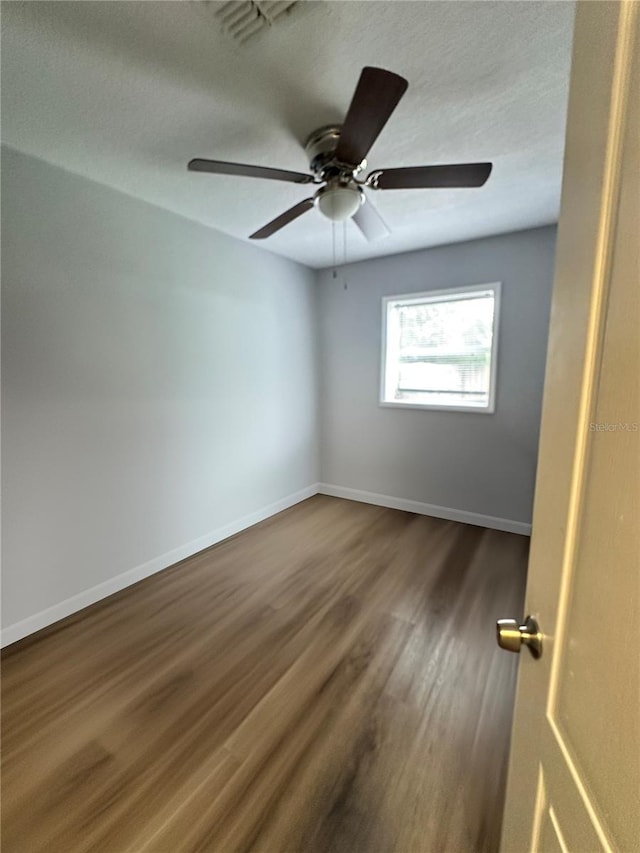 unfurnished room featuring a textured ceiling, dark hardwood / wood-style floors, and ceiling fan