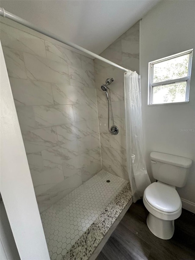 bathroom featuring hardwood / wood-style floors, toilet, and walk in shower